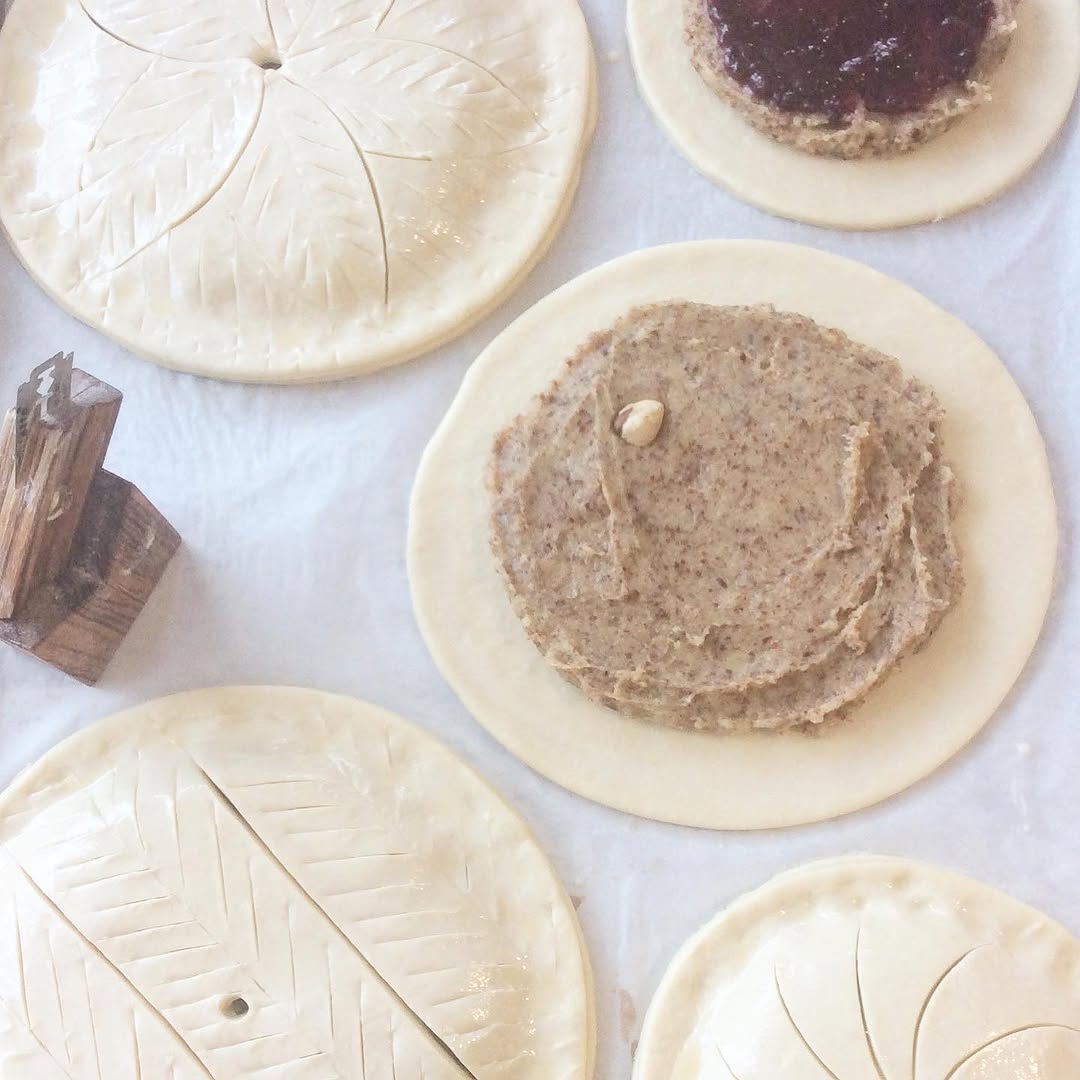 Galette des rois preparation — puff pastry rounds scored with decorative patterns, frangipane filling